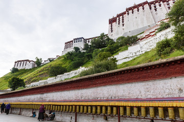 Prayer wheels around in the back of the Historic Ensemble of the Potala Palace in Lhasa, Tibet,...
