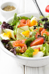 Salad with salmon, egg and vegetables (cherry tomatoes, cucumber, lettuce), delicious light lunch, healthy food