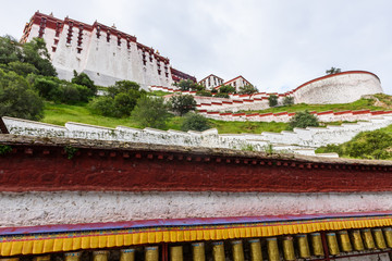 Prayer wheels around in the back of the Historic Ensemble of the Potala Palace in Lhasa, Tibet,...