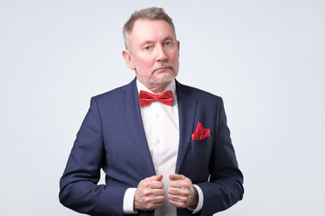 Senior lawyer wearing blue suit while standing against white background.