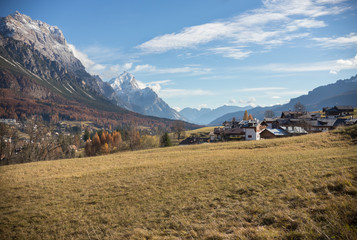 Dolomites nature. A yellow autumn field and country houses
