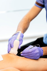 Obraz na płótnie Canvas Physiotherapist giving knee therapy to a woman