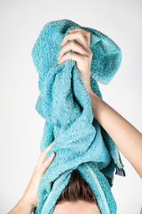 Female drying her hair with towel. Close-up of woman using bath towel for manual hair drying