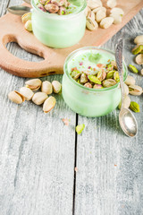 Vegan trend food. Homemade pistachio yogurt with fresh pistachios. On a white wooden table, copy space