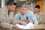 woodworkers studying a blueprint