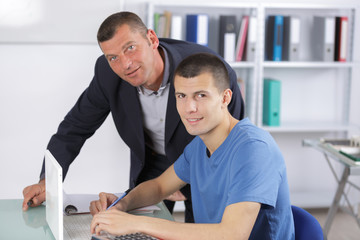 Fototapeta premium computer teacher assisting a student in classroom