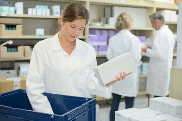 Obraz premium woman pharmacist wearing uniform and working with boxes