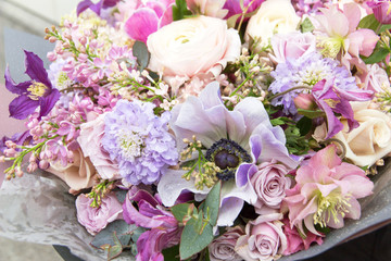 Beautiful elegant soft pink purple violet bouquet by florist with different flowers and roses close-up, macro. Floral background	