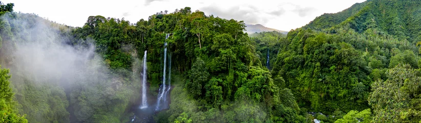 Fototapete Wasserfall Antenne über den Wasserfall Sekumpul, umgeben von dichtem Regenwald und Bergen, die bei Sonnenaufgang in Nebel gehüllt sind, Bali, Indonesien Panorama  © Studio-FI