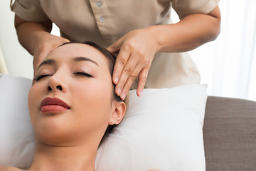 Obraz na płótnie Canvas Ayurvedic Head Massage Therapy on facial forehead Master Chakra Point of Mix Race Caucasian Asian woman, Therapist Spa body woman hands treatment on customer to increase circulation release tension