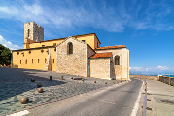 Fototapeta na wymiar Antibes Cathedral and road along the sea in France.