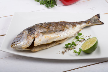 Grilled dorado fish served on a white plate