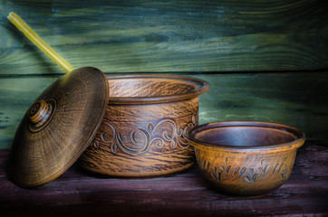 Empty clay pots on wooden background. Play with the light.