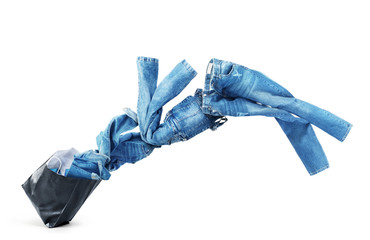 Denim clothes flying out of a black bag isolated on white background. Sale.