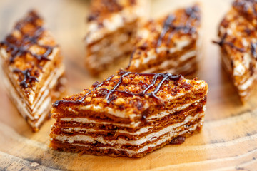 Pieces of cake with layers of cream on the canvas on a wooden table