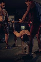 Man helping his friend doing bench press