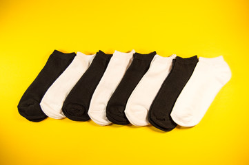 black and white socks on yellow background isolated