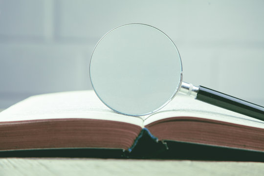 Magnifying Glass And A Book On The Table