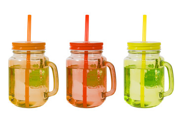 Three colored glass glasses with tubes, orange, red and green, on a white background, isolated