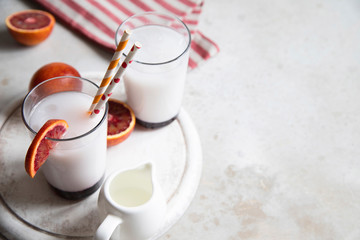 Two glasses of Italian soda with blood orange syrup, milk and ice.
