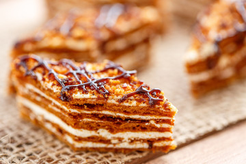 Pieces of cake with layers of cream on the canvas on a wooden table