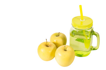 Transparent green glass glass Cup with a tube filled with juice and three yellow apples, on a white background, insulated