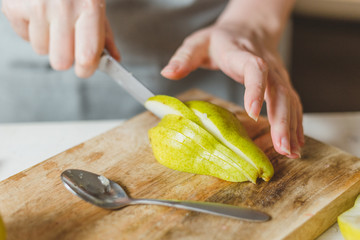 Fresh pears and pomegranates in the kitchen on a cutting wooden board for making salad - rustic...