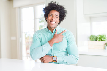 African American business man wearing elegant shirt cheerful with a smile of face pointing with hand and finger up to the side with happy and natural expression on face