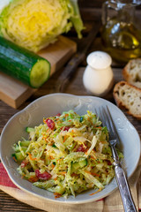 Fresh salad of napa cabbage with carrots, cucumber and salami