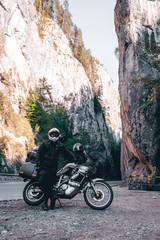 Motorcyclist man on adventure motorbike on mountain road in Bicaz Canyon, Romania. Tourism and vacation concept, moto way, motorcycle extreme tour, best road for motorcycle, vertical photo
