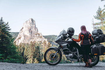 Fototapeta na wymiar Woman biker and adveture motorcycle on mountain road in Bicaz Canyon, Romania. Travel concept, extreme, vacation in Europe, motorcyclist way, tourism, Cheile Bicazului, Europe. copy space