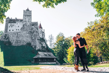 Happy young couple hugging kisses dancing, man and woman. Brasov, Transylvania. Romania. The medieval Castle of Bran. Travel and vacation to Europe, tour. beautiful sunny day, copy space