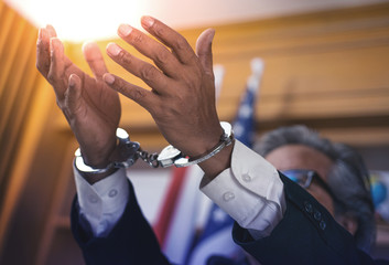 Close up business man hands with handcuffs, selective focus, corruption concept