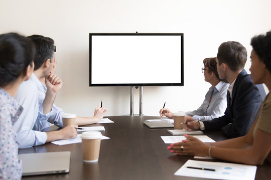 Business people group sitting at conference table looking at screen
