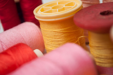 closeup of colorful sewing thread spool bobbins on white background