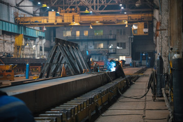 A man worker using a welding machine on a construction site indoors