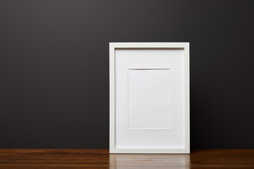 white decorative, square frame on wooden table