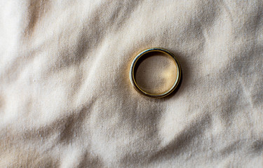 Gold ring over beige cloth