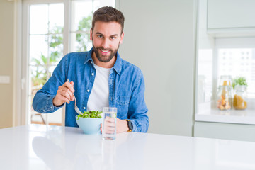 Fototapeta na wymiar Handsome man eating green peas at home