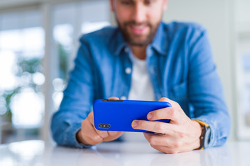 Close up of man hands using smartphone and smiling