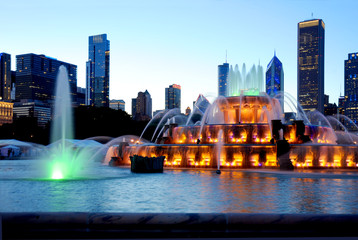 Naklejka premium Pokaz fontanny wodnej w środku Chicago o zmierzchu w spektakularnych kolorach.