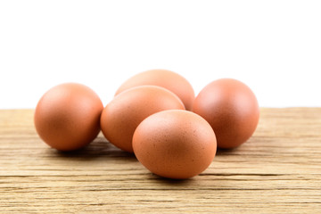 Brown chicken eggs on wooden table isolated on white background