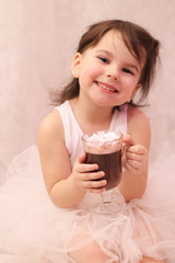 funny girl in ballerina tutu with a glass of hot drink in her hands