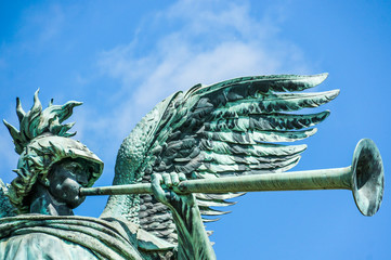 Angel statue playing the trumpet in front of blue sky © pixxelmixx