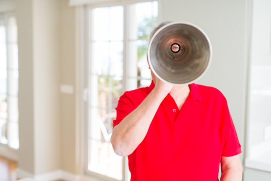 Senior man shouthing excited through vintage metal megaphone