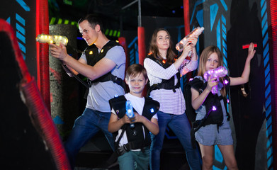 Obraz na płótnie Canvas Kids with parents during lasertag game