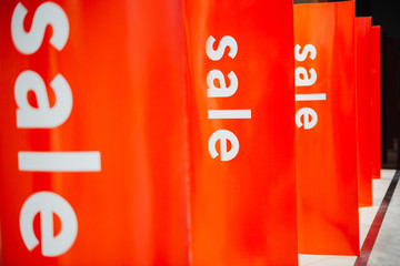 Sale signs on the entrance of the shop on the red background
