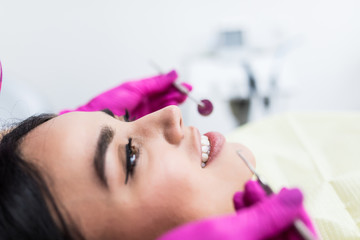 Fototapeta premium Young woman having dental check-up in dentist office, smiling.