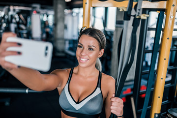 Beautiful sporty woman taking selfie at the gym.