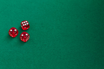 Red dice on green and black background. Copy space for text